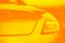Fashionable sports yellow orange gradient color car. Fragment, details. Yellow toned photo