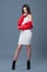 Fashionable style, fashion women`s clothing, color combination. Beautiful brunette girl in white dress and red leather jacket