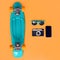 Fashionable summer colorful blue skateboard, sunglasses, vintage film camera, frameless smartphone screen on orange background