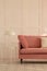 Fashionable velvet pastel pink couch in white living room interior