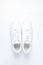 Fashionable white sneakers on white background, minimalism, top view, creative layout.
