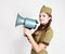 fashionable woman in military uniform and garrison cap, holding bullhorn and screaming