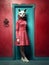 Fashionable woman in a red dress with a cat mask - Generative AI