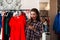 Fashionable woman in shirt holding and want buying elegant red dress.