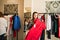 Fashionable woman in shirt holding and want buying elegant red dress.