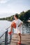 Fashionable woman standing on the pier near lake