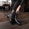 Fashionable woman stands in a store and measures autumn shoes. Closeup of female legs in stylish jeans in trendy leather black