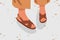 Fashionable woman street strap sandals. Female feet in stylish elegant flat sole open toe footwear. Pair of summer