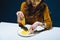 fashionable woman with unhealthy meat pastry sitting at table