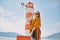 Fashionable woman on vacation against the backdrop of the sea, mountains and a lighthouse. Summer, sunny day, walk along the beach