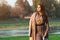 Fashionable woman walking in city park. Beauty and fashion. Stylish girl wearing trendy dress and coat