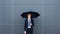 Fashionable young man with dark blue umbrella walking confidently in the rain, copy space available