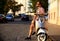 Fashionable young man riding a vintage scooter in street