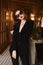 Fashionable young model woman in an elegant black suit and black sunglasses. Beauty, fashion. Optics and eyewear