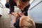 Fashionable young mother kneeling down to apply pink lipstick on her daughter