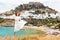 fashionable young woman jumping at the background of white Lindos town in Rhodes. Travel and adventures in Greece