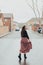 Fashionable young woman wetting her skirt and smiling in the rain with black boots and printed long skirt