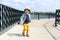 Fashionably dressed cute little boy in straw hat walks in summer