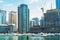 Fast development in Dubai city. High buildings and construction site with industrial cranes at Dubai Marina with luxury