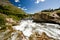 A fast flowing glacial river, rushing over rocks towards the camera in the Colorado mountains