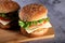 Fast Food - Burgers on a wooden mat with textured background