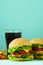 Fast food frame. Delicious meat burgers on blue background. Take away meal. Unhealthy diet concept with copy space