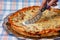 Fast food. Lady preparing to cut pizza, close-up