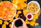 Fast food and unhealthy eating concept - close up of pizza,, french fries and potato chips and candies on wooden table top view