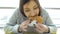 Fast food. Young woman with an appetite eating a burger