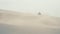 A fast military motorcycle riding through desert dunes