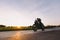 Fast motorcycle drive on asphalt road at sunset