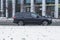 Fast moving BMW X7 on winter city road. Black SUV with man driving. Premium big auto in fast motion with blurred snowfall
