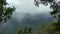 Fast moving clouds rising along misty foggy tropical rainforest mountains, view from mountain peak, Gunung Panti, Malaysia
