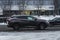 Fast moving Nissan Murano Z52 on the winter city road. Black SUV driving on motorway. Used auto in fast motion with blurred
