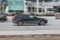 Fast moving Volvo V60 on the city road. Black compact executive car rides on street. Dirty auto in fast motion with blurred