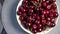 Fast rotating bowl of sweet cherries on the table.