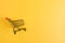 Fast shopping cart on yellow background with copy space for text