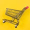 Fast shopping cart on yellow background with copy space for text