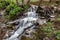 A fast stream in mountainous terrain. Water flowing in the river shown in a long exposure.