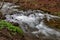 A fast stream in mountainous terrain. Water flowing in the river shown in a long exposure.