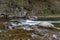 A fast stream in mountainous terrain. Water flowing in the river shown in a long exposure.