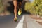 Fast strong runner feet running on asphalt road