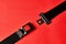 Fastened seat belt on red background with copy space, close-up