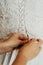 Fastening the wedding dress, closeup on hands