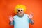 Fat amazed man with beard, tattoos and sunglasses has fun with the yellow wig