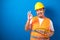 Fat asian construction worker wearing orange safety vest and helmet showing okay sign