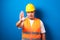 Fat asian workman wearing orange safety vest and yellow helmet making stop gesture