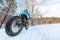Fat bike biking girl riding on snow trail path in winter. Outdoor sport in nature landscape