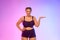 Fat bodypositive woman standing isolated over pink background. Girl showing or pointing on copyspace .