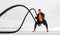 Fat burning battle rope workout. Athletic man doing sports exercises on the ocean beach